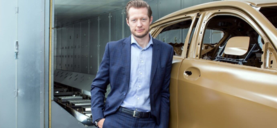 Wenkler CEO Stefan Leers leaning on a car as it leaves the production line